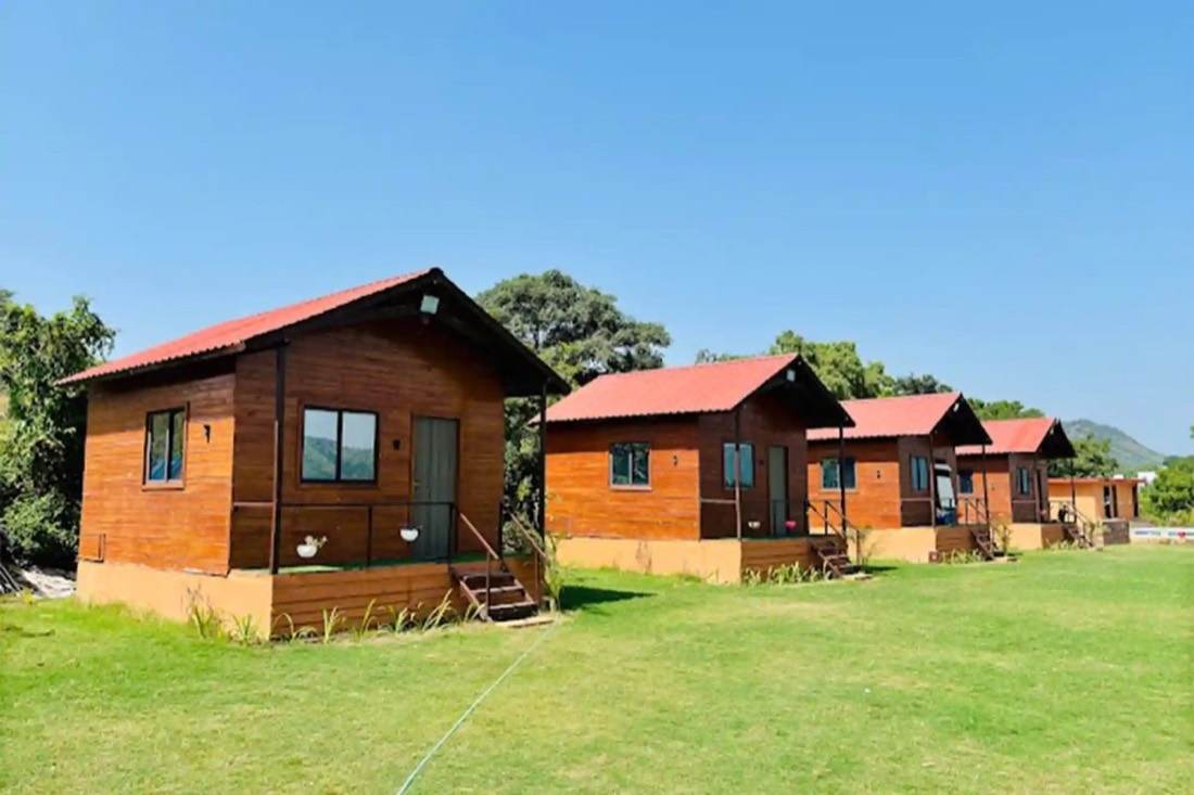 Wooden cottages on the lawn at The Udaisarovar